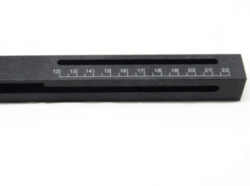 A close-up image of a black rectangular measuring tool with a slot and markings numbered from 12 to 22.