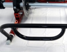 Close-up of a mechanical component featuring a black metal handle and a red and silver cylindrical structure with a visible bolt and disc mechanism.